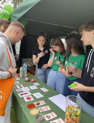 Członkowie Koła Naukowego Technologów Żywności prowadzą aktywność edukacyjną przy stoisku, prezentując materiały i próbki związane z żywnością